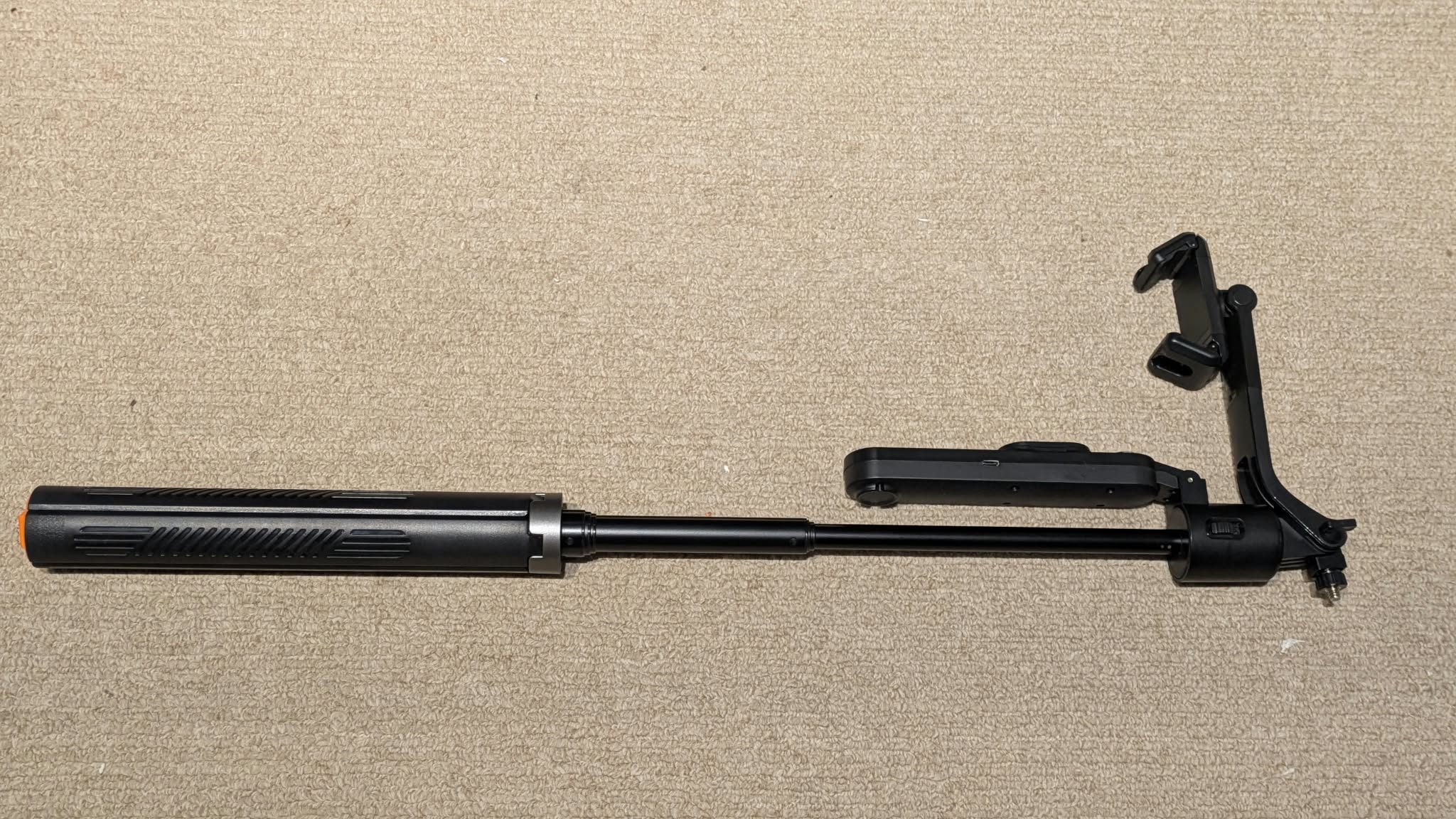 Selfie stick fully extended, top view on carpet